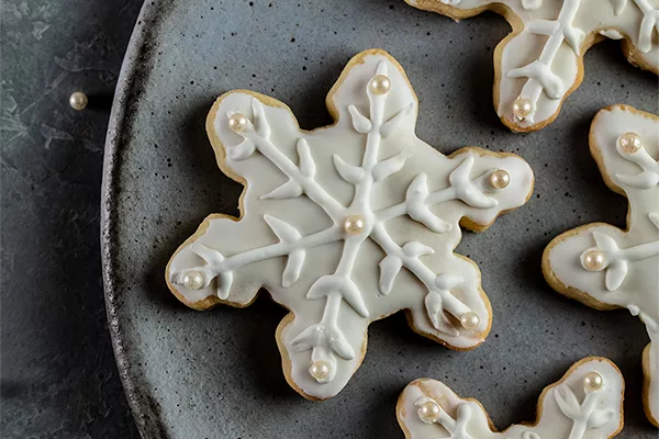 snowflake sugar cookie decorateed with domino sugar royal icing