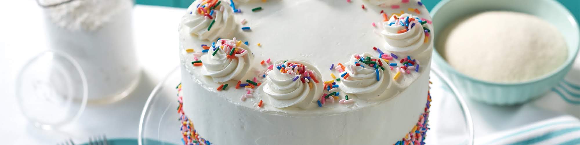 rainbow sprinkles cake with domino powdered sugar cream cheese frosting