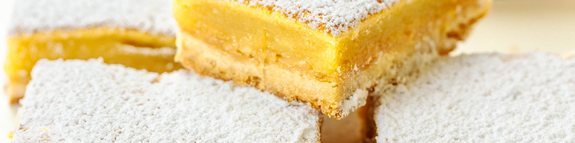 lemon bars made with domino golden sugar and light brown sugar, topped powdered sugar 