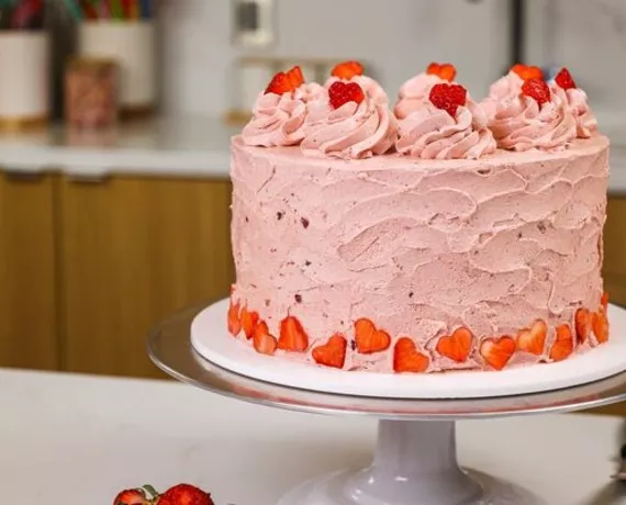 domino golden sugar strawberry layer cake with strawberry frosting and heart-shaped strawberries