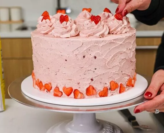 domino golden sugar strawberry layer cake with strawberry frosting and heart-shaped strawberries