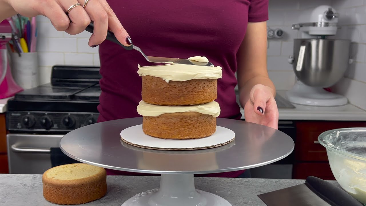 assembling a cake with Domino® Sugar buttercream frosting